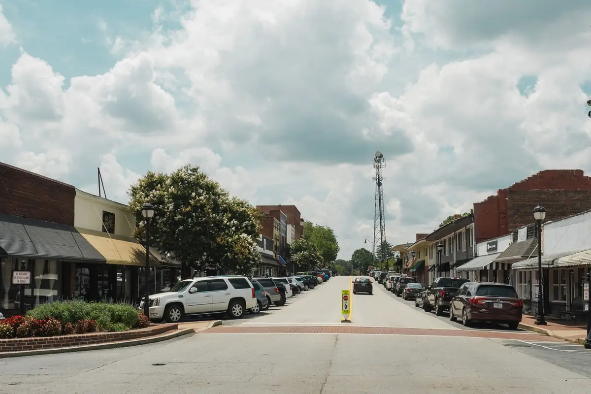 Storefront main street of a small Southern town under big summer clouds