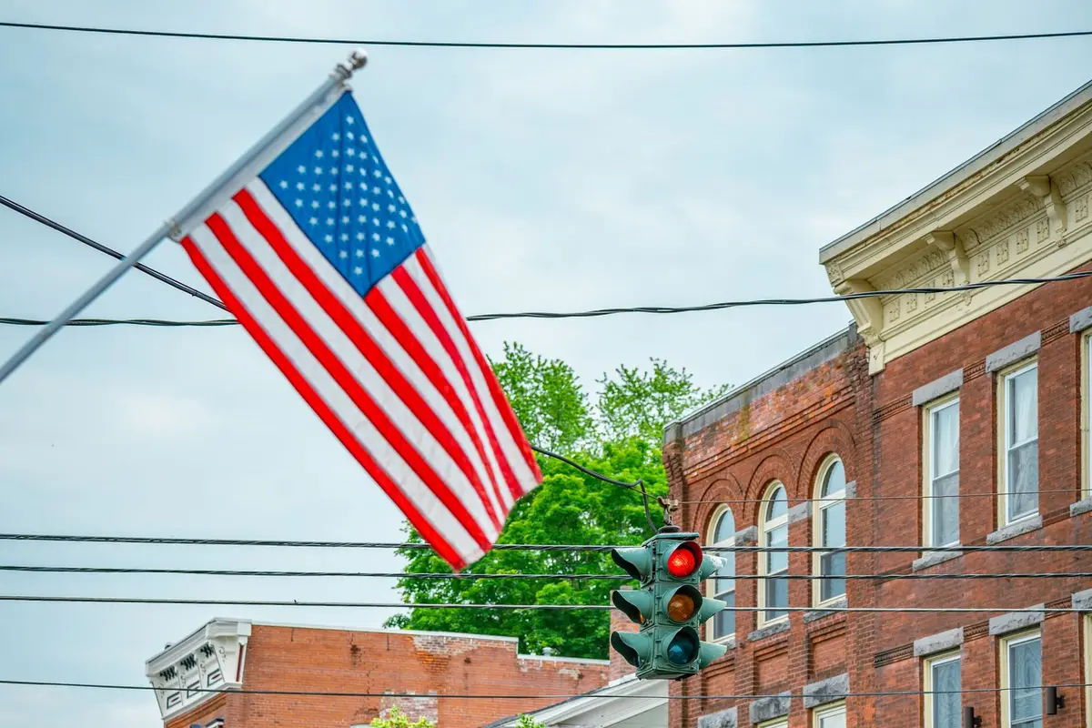 Small town main street lined with brick storefronts and American flags